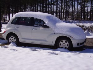 Car with layer of snow on it